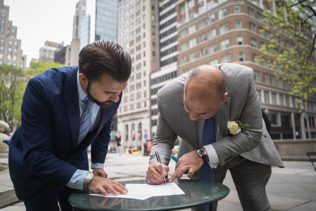 Couple signing their marriage license during a Manhattan ceremony
