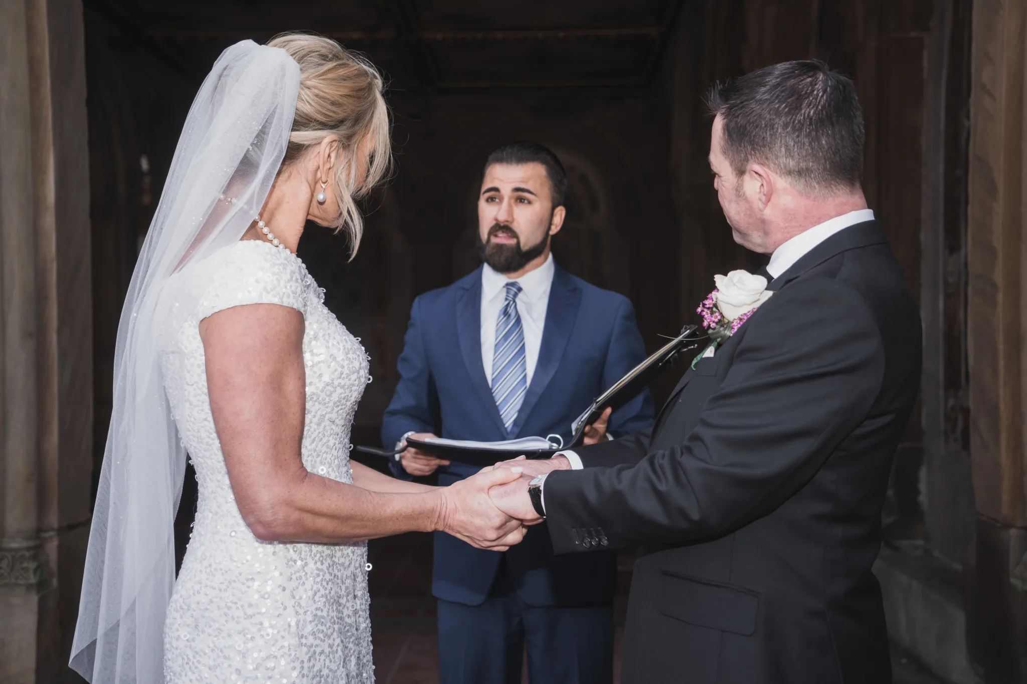 Wedding officiant leading a Central Park ceremony as a couple holds hands